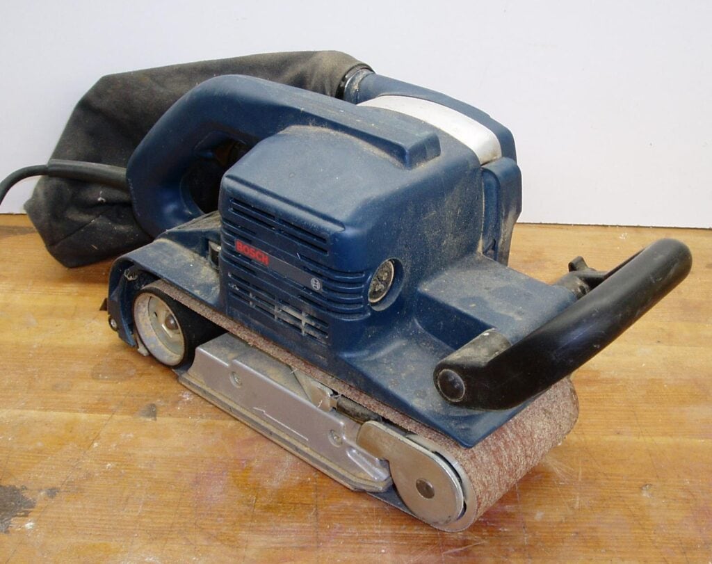 A Bosch belt sander on top of a wood table Belt Sander