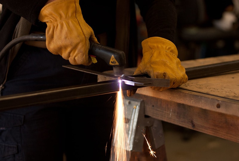 A plasma cutter cutting a steel tube How Does a Plasma Cutter Work featured photo