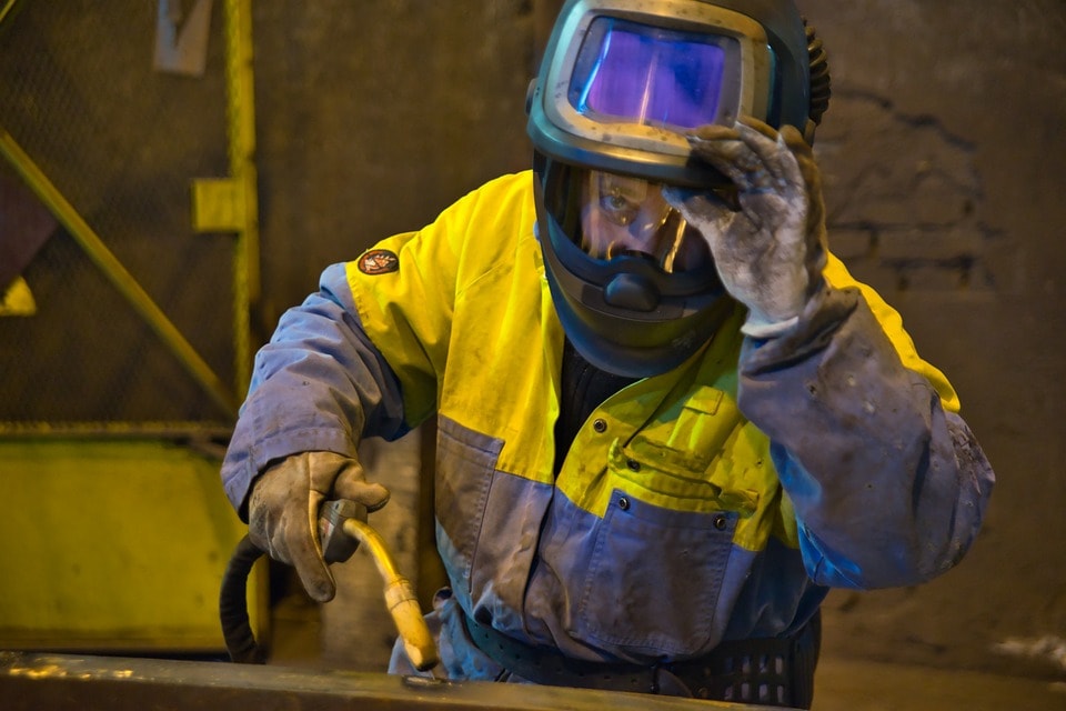 A man using safety equipment to handle a plasma cutter Use Safety Gear In Using Plasma Cutter